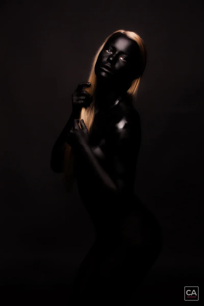 Bodypainting-Pose vor schwarzem Hintergrund