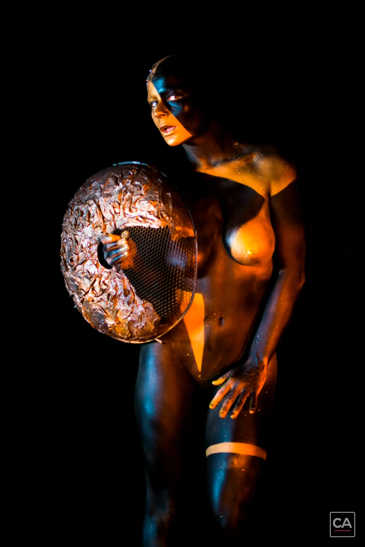 Goldenes Bodypainting mit rundem Requisit