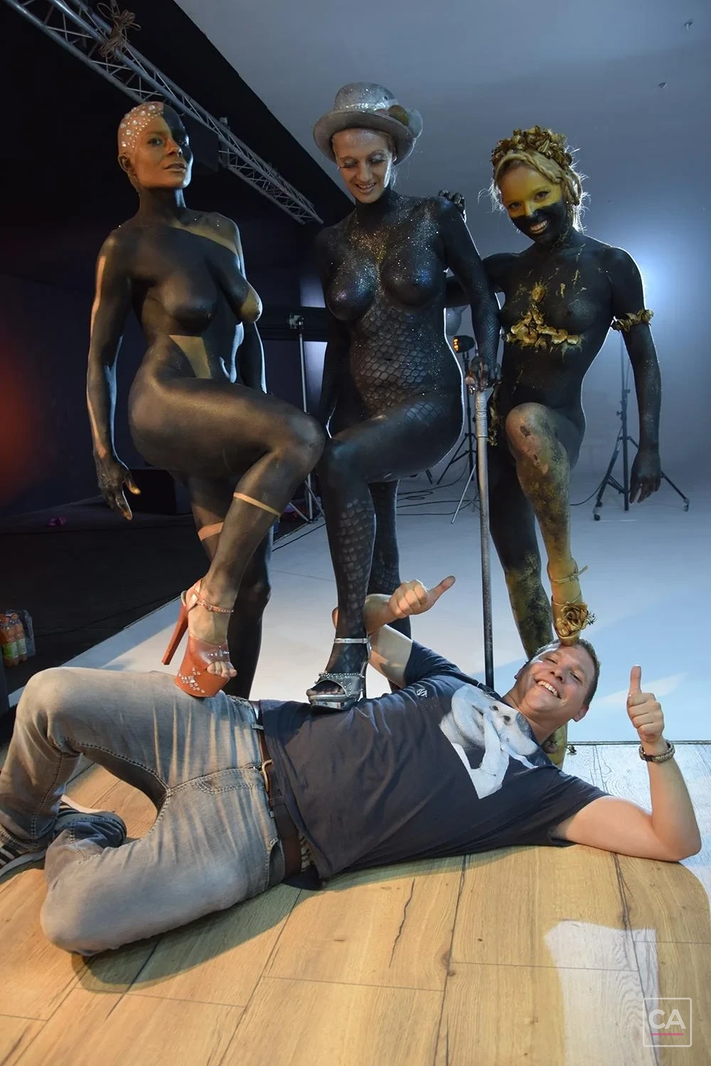 Fotograf und drei Bodypainting-Models am Set