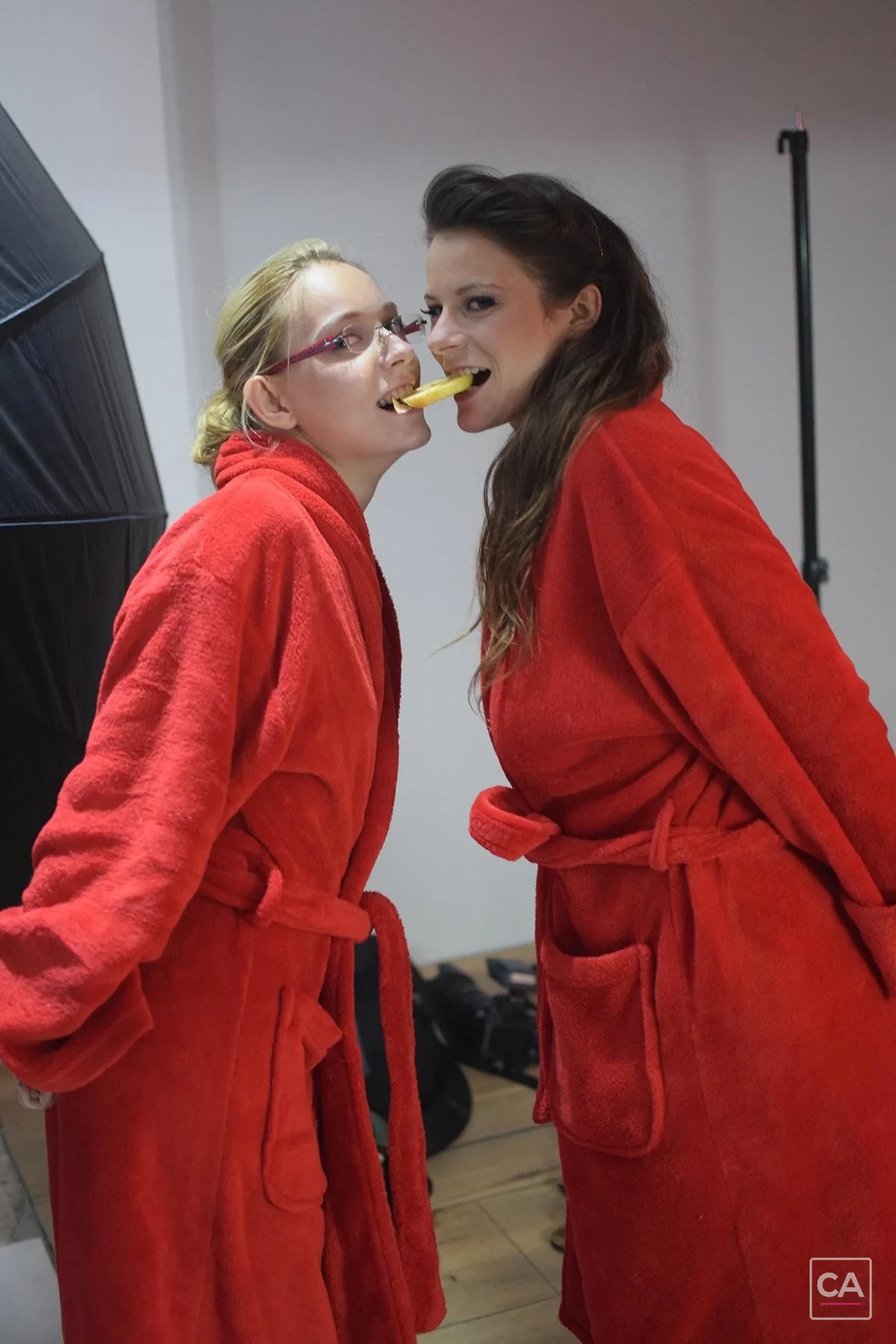 Zwei Models in roten Bademänteln am Set