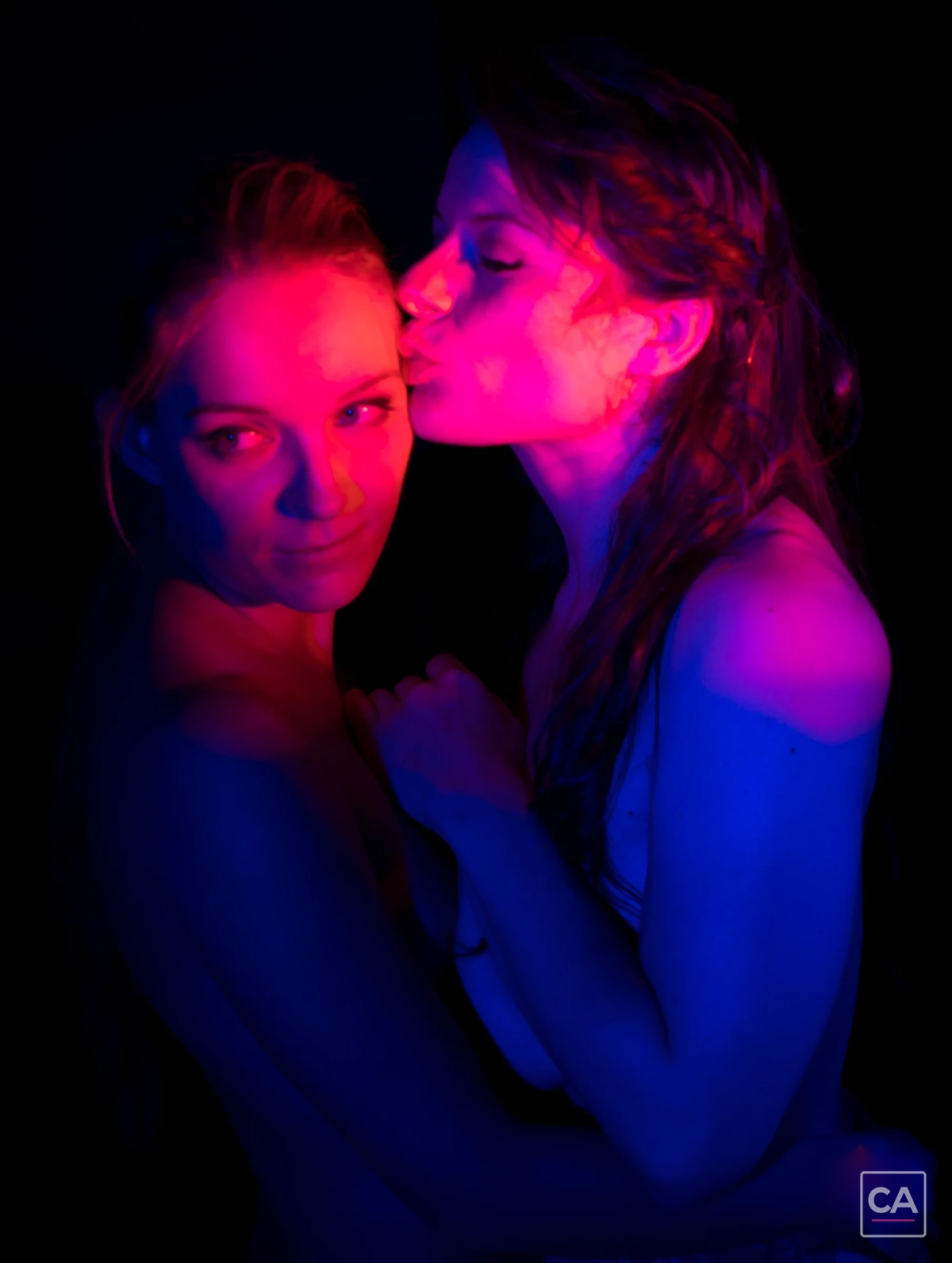 Zwei Models zwischen den Aufnahmen im farbigen Studiolicht