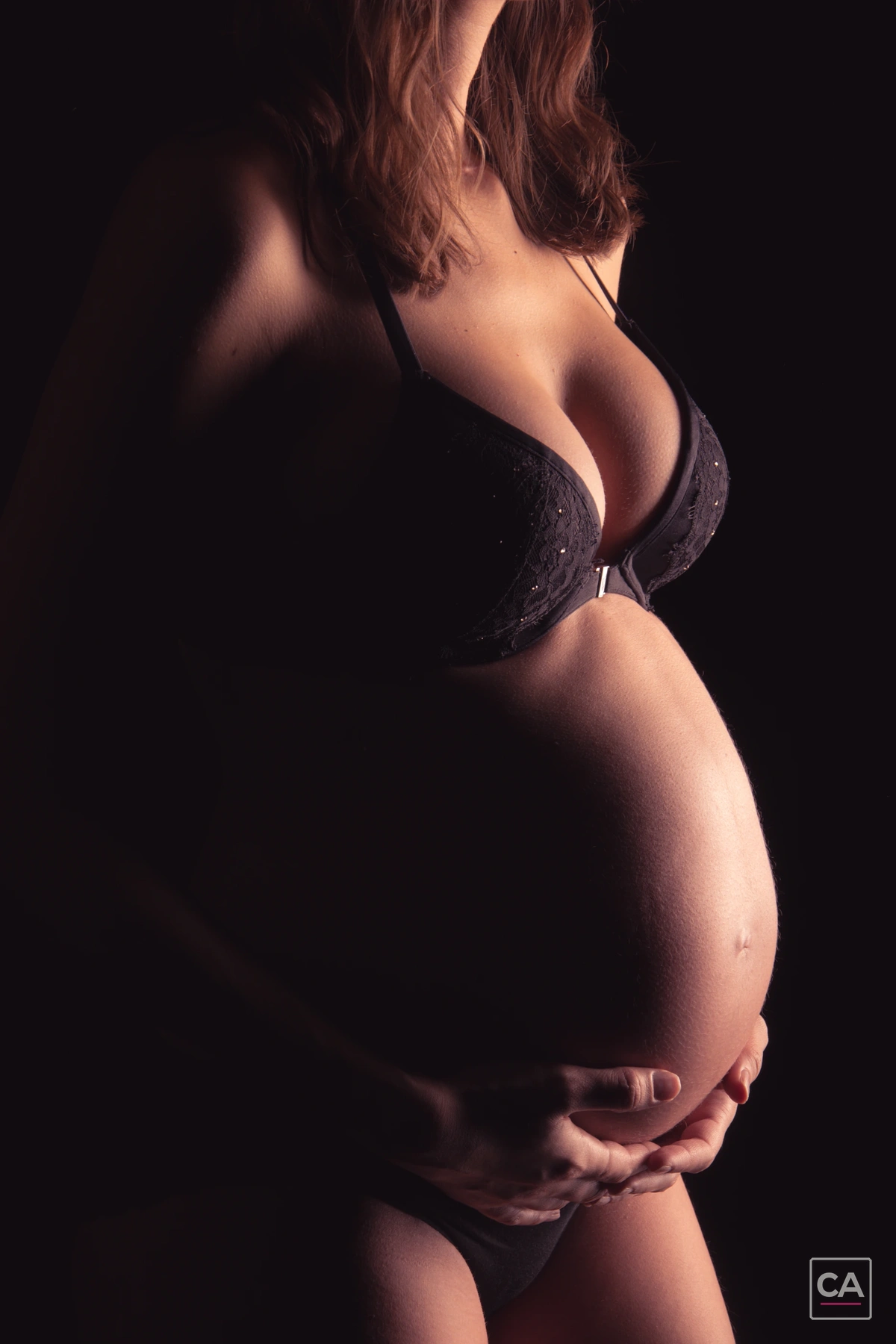Babybauch im warmen Studiolicht